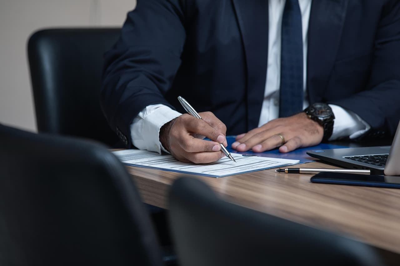 Executive signing documents, illustrating the Hummingbird Quantimon acquisition
