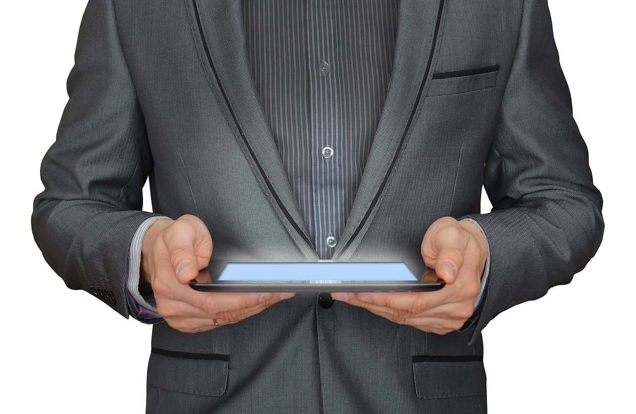 Business buyer in a suit using a tablet, illustrating Walmart Business Pay By Invoice