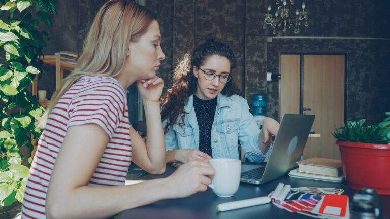 Two women discuss something on a laptop.jpg
